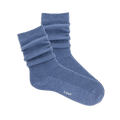 Pair of ribbed, slouchy crew socks in a dusty blue color, shown on a black background. 'k.bell' logo visible on sole.