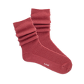 Pair of ribbed, slouchy crew socks in a muted red-orange color, shown on a black background. 'k.bell' logo visible on sole.