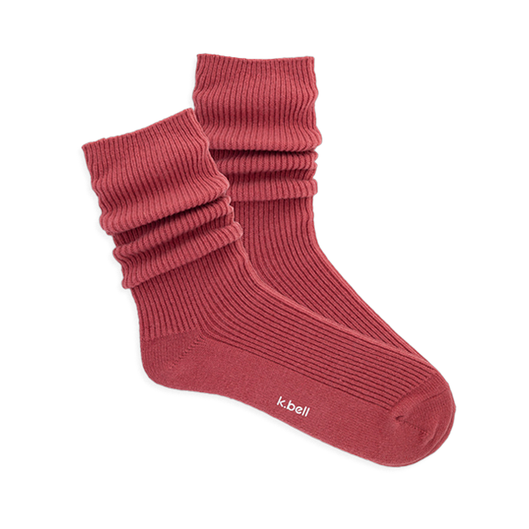 Pair of ribbed, slouchy crew socks in a muted red-orange color, shown on a black background. 'k.bell' logo visible on sole.