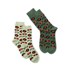 Two pairs of crew socks laid flat. One pair is light green with music patterns, the other is dark green with the same design.