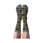 Person's legs wearing light green crew socks patterned with orange boomboxes, black records, and musical notes.