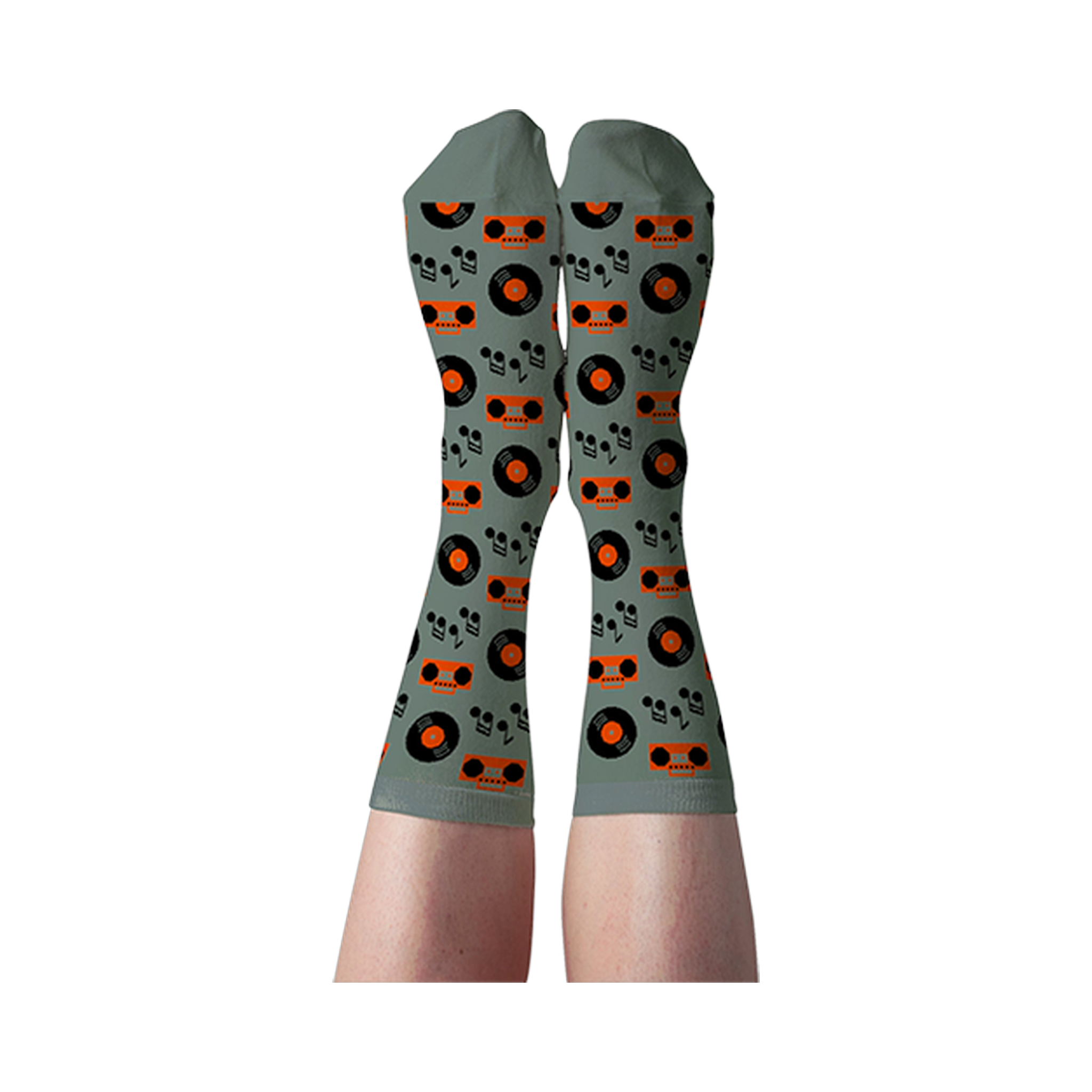 Person's legs wearing light green crew socks patterned with orange boomboxes, black records, and musical notes.