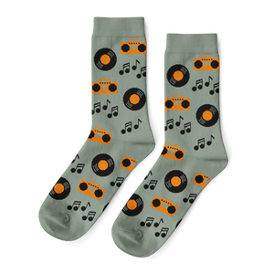 Pair of light green crew socks with a repeating pattern of orange boomboxes, black vinyl records, and music notes.