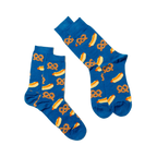 Two blue crew socks with hot dog and pretzel pattern, laid flat and angled on a white surface, one slightly overlapping.