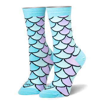 Crew socks featuring a mermaid scale pattern in pastel blue, teal, and lilac with black outlines and solid light blue cuffs.