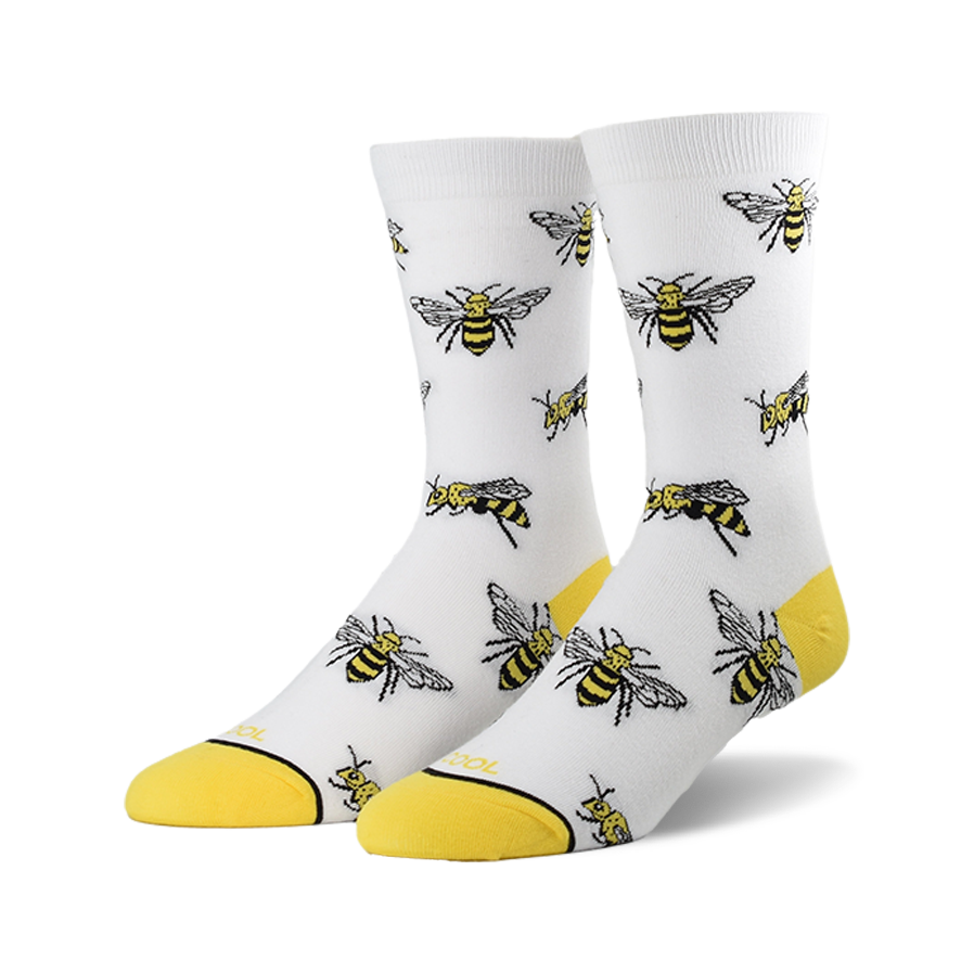 A pair of white crew socks with a repeating pattern of illustrated bees and yellow cuffs.