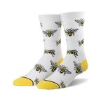 A pair of white crew socks with a repeating pattern of illustrated bees and yellow cuffs.