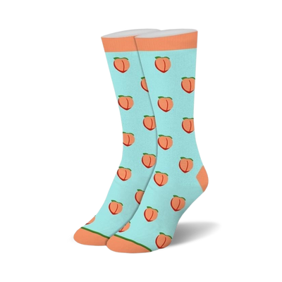 A pair of light blue crew socks with an all-over pattern of orange peaches, green leaves, and orange cuffs, heels, and toes.