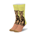 A pair of crew socks showcasing a brown tabby cat design on a lime green background with pink polka dots and stripes. The socks have brown heels and toes.