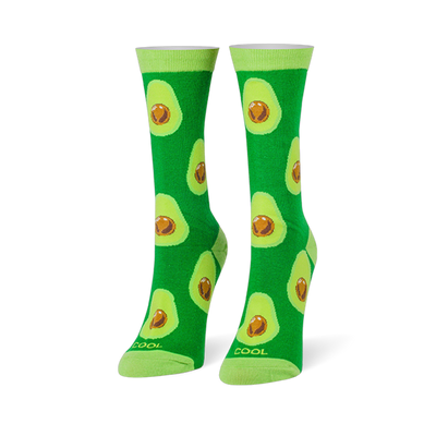 Bright green crew socks covered in halved avocados with brown pits, featuring light lime green cuffs and toes.