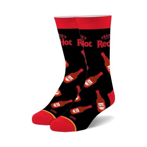 Pair of black crew socks featuring repeated images of Frank's RedHot sauce bottles in red and white on a black background. Red accents at the cuffs.