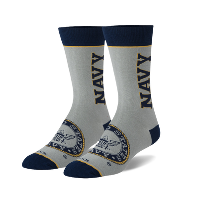 Pair of light gray crew socks with 'NAVY' in gold lettering, a US Navy emblem, navy cuffs, heels, toes, and yellow stripes.