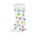 A pair of white crew socks with a 'Birthday Bitch!' slogan and colorful balloon illustrations.  Stars, hearts, and round balloons in pink, blue, yellow, and green.