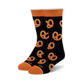 Pair of black crew socks with an all-over pattern of orange pretzels and white dots. Orange cuffs.