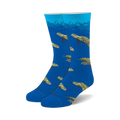 Pair of blue crew socks with a repeating pattern of sea turtles swimming underwater. Green and brown turtles on a bright blue background.