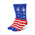 A pair of crew socks in blue and red. The socks feature an American flag design with white cannabis leaves on the blue portion.