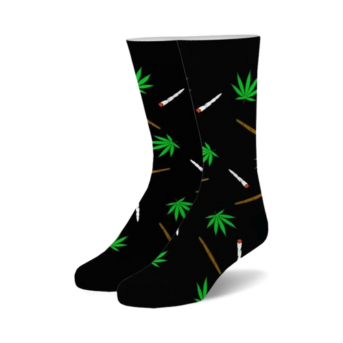 Pair of black crew socks with a whimsical design.  Green marijuana leaves and stylized joints are scattered across the black fabric.