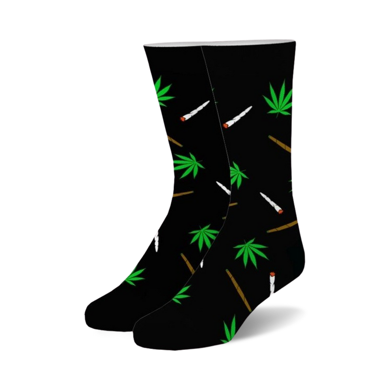 Pair of black crew socks with a whimsical design.  Green marijuana leaves and stylized joints are scattered across the black fabric.