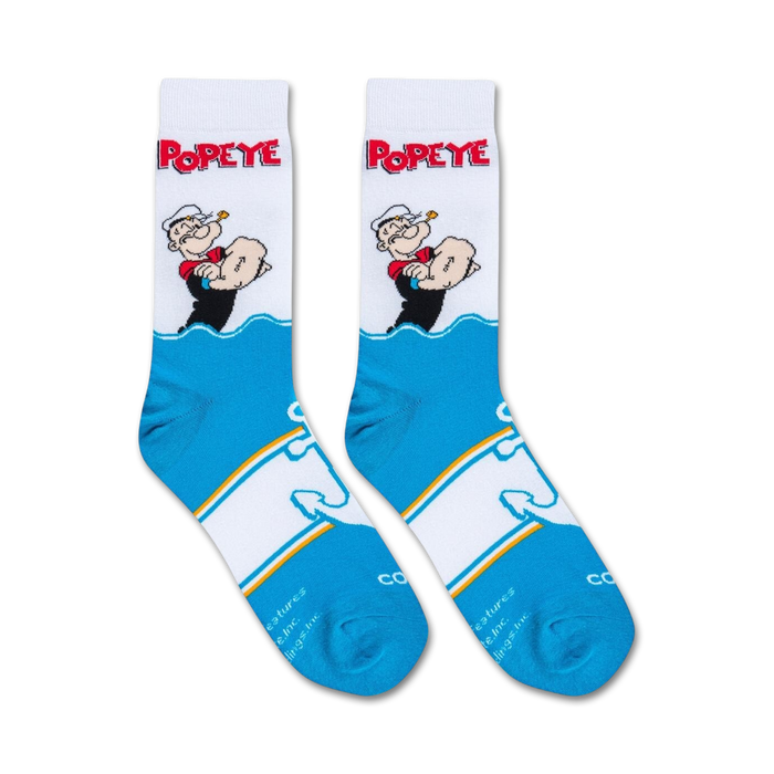 A white sock with a cartoon character, Popeye the Sailor Man, on the leg. He is wearing his signature white hat and red shirt with black sleeves. The sock is over a black background.