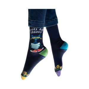 Lifestyle shot of model wearing Pete the Cat socks, showing how they look on feet with jeans.