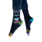 Lifestyle shot of model wearing Pete the Cat socks, showing how they look on feet with jeans.