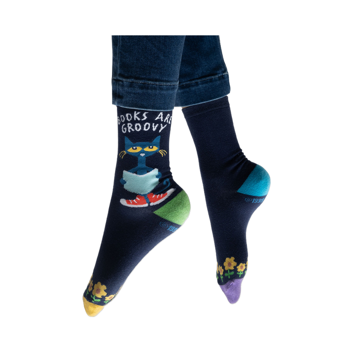 Lifestyle shot of model wearing Pete the Cat socks, showing how they look on feet with jeans.