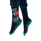 Lifestyle shot: Person wearing navy blue socks with teal stripes and a Richard Scarry apple car design.