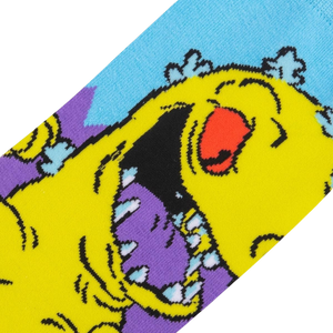 A yellow cartoon monster with purple teeth and a red nose is depicted with its mouth wide open against a blue background.