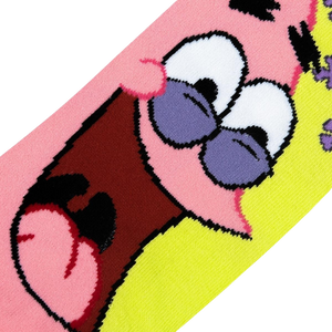 A close up image of a pink and yellow sock with a cartoon character on it. The character has large white eyes with purple eyelids and a wide open mouth.