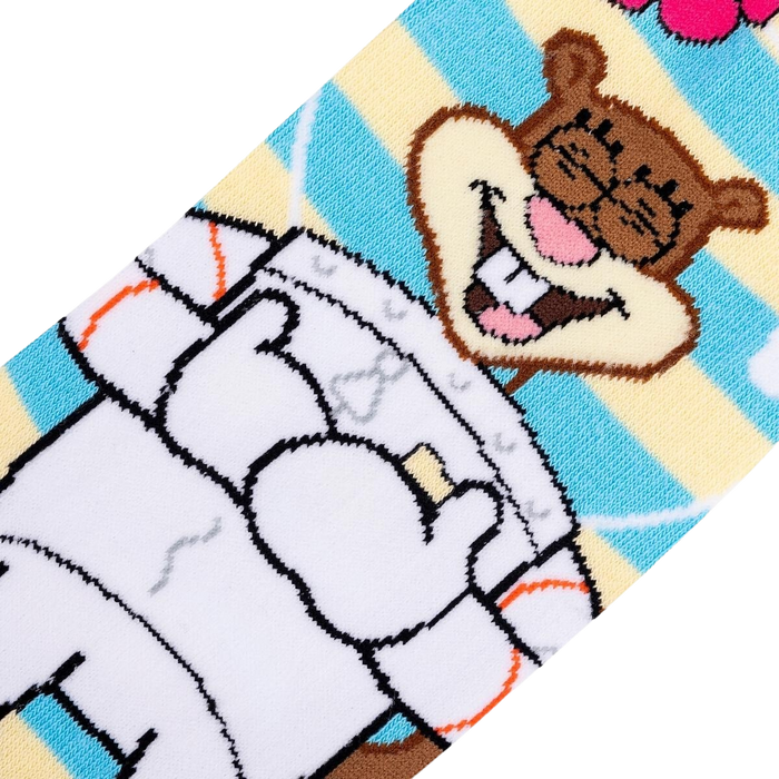 A close up of a pair of socks with a pattern of Sandy Cheeks from the cartoon Spongebob Squarepants. Sandy is smiling with her arms in the air. The socks are blue and white striped with a yellow toe and heel.