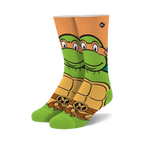 Crew socks featuring Michelangelo from TMNT. Green, orange, and brown colors.  Mikey's face and shell are prominently displayed.