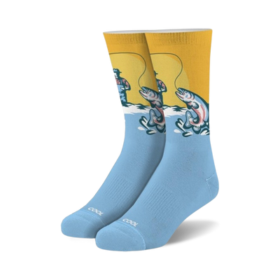 light blue fishing crew socks feature a fisherman wearing a red hat and blue overalls standing in a river fishing, with the word "cool" on the bottom.  