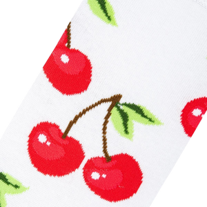 A white sock with a pattern of red cherries with green leaves.