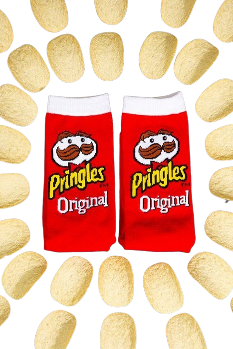 A pair of red socks with a white toe and white top. The word Pringles is written vertically in yellow letters on each sock, along with the Pringles logo, a cartoon character with a mustache. The socks are displayed on a black background with a pattern of potato chips.