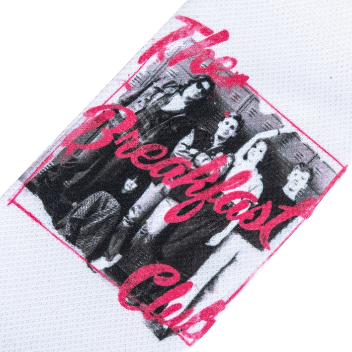 A white cotton headband with a sublimated image from the movie The Breakfast Club. The image is of the five main characters in the movie, standing in front of lockers. The headband has a pink border and the words 
