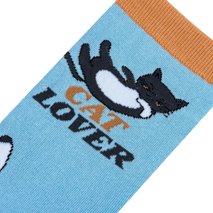 A pair of blue socks with orange toes, heels, and cuffs. The socks have a repeating pattern of cartoon cats in various poses. The words 
