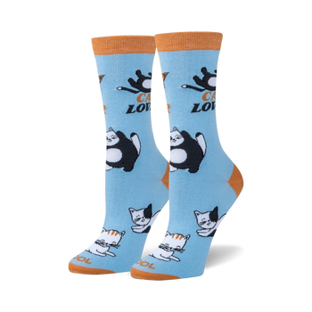 blue crew socks with allover pattern of cartoon cats in black, white, and orange.   