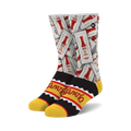A pair of crew socks showcasing a repeating pattern of Tapatio hot sauce packets on a white background. The cuff features a black and yellow Tapatio logo.