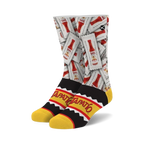 A pair of crew socks showcasing a repeating pattern of Tapatio hot sauce packets on a white background. The cuff features a black and yellow Tapatio logo.