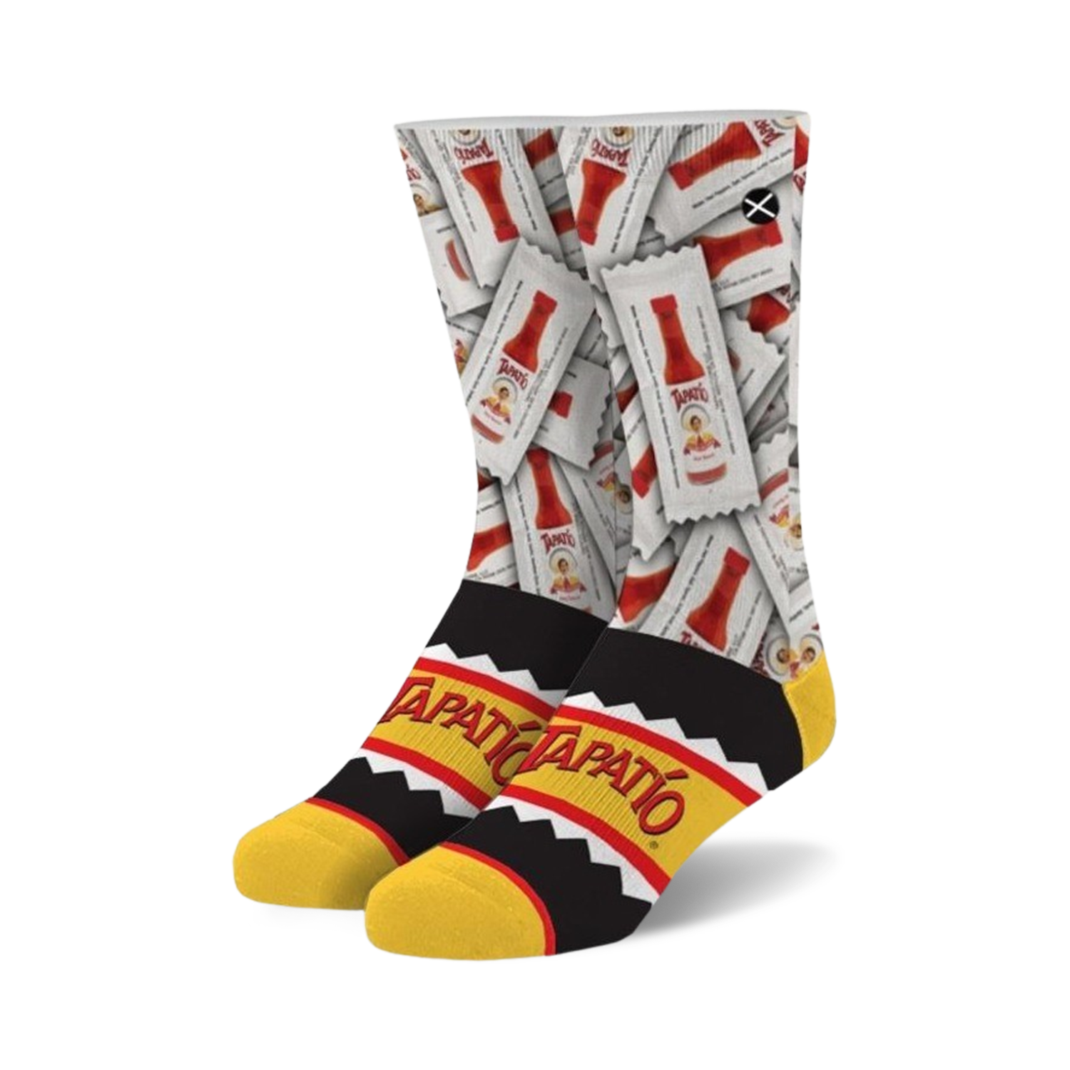 A pair of crew socks showcasing a repeating pattern of Tapatio hot sauce packets on a white background. The cuff features a black and yellow Tapatio logo.