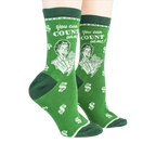 Lifestyle shot showing a pair of green 'Accountant' socks on a person's feet.
