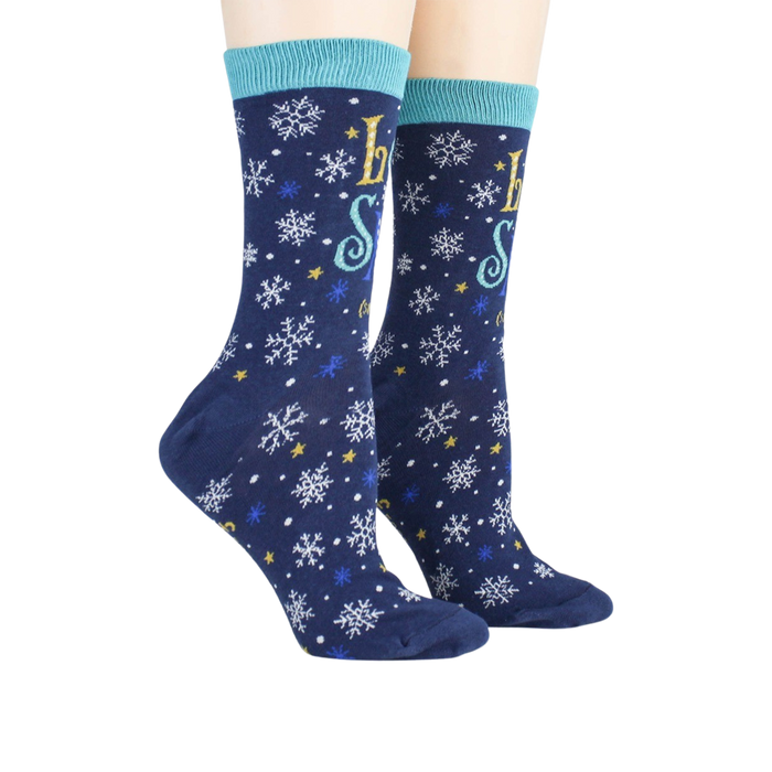 A pair of blue socks with a snowflake pattern and the words 