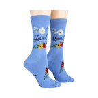 Lifestyle photo showing 'Blessed' socks on a person's feet. The socks are light blue with floral designs.