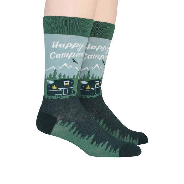 A pair of green socks with a pattern of mountains, trees, and a camper. The words 
