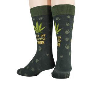 A pair of dark green socks with a marijuana leaf pattern and the words 