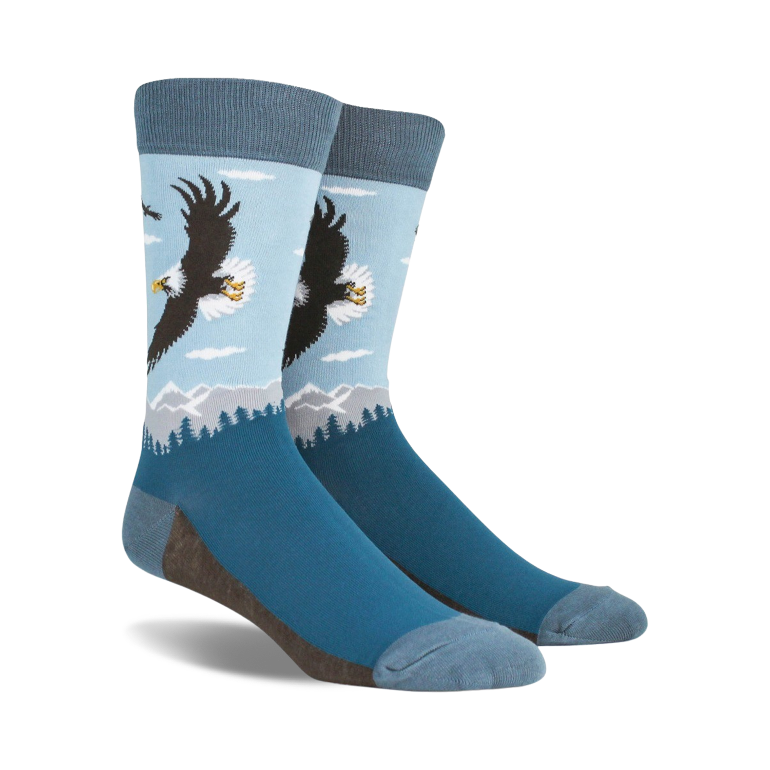 A pair of blue crew socks with a graphic design of a bald eagle soaring over a mountain landscape. 