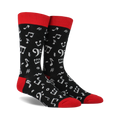 Pair of black crew socks with a red cuff.  White musical notes and symbols are printed all over.