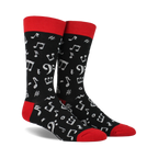 Pair of black crew socks with a red cuff.  White musical notes and symbols are printed all over.