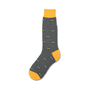 A gray sock with a yellow toe, heel, and cuff. The sock is decorated with a pattern of bees and beehives.