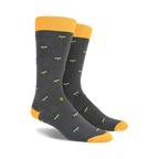 A pair of charcoal gray crew socks with a repeating pattern of yellow bees and honeycombs. Yellow tops.